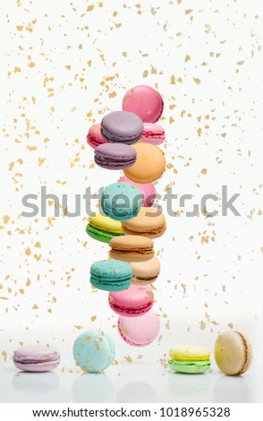 Different types of macaroons in motion falling on white background. Sweet and colourful french macaroons falling or flying in motion. Royalty-Free Stock Photo #1018965328