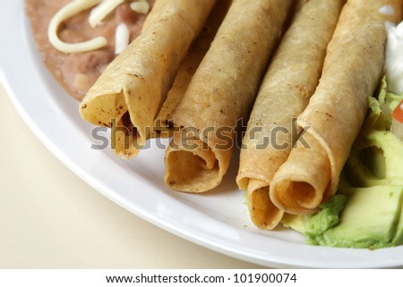 Flautas / Typical Mexican plate. Rolled tacos served as a meal with a side of beans and rice.