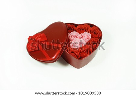 A red heart shape of steel gift box with roses inside made from soap isolated with white background.