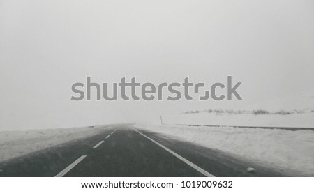 The road to unknown. The snowy blizzard , with poor visibility ahead. With no one around. The picture was taken from a car, with no certainty what comes ahead. In the Montenegro mountains, 12/08/17.