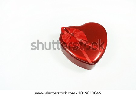 Close up shot of love shape gift box made from steel with red ribbon isolated with white background.