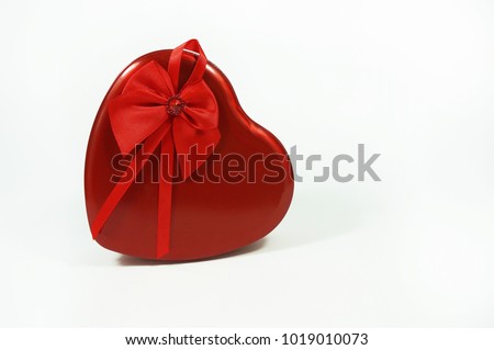 Close up shot of love shape gift box made from steel with red ribbon isolated with white background.