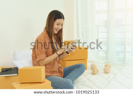 Asian young woman business work at home for online shopping and sale.small and medium enterprise business ,sale online concept,happy to sale