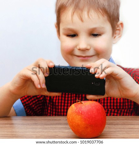 Boy Takes Pictures of the Apple on Smartphone.