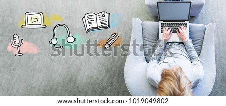 E-Learning with man using a laptop in a modern gray chair Royalty-Free Stock Photo #1019049802