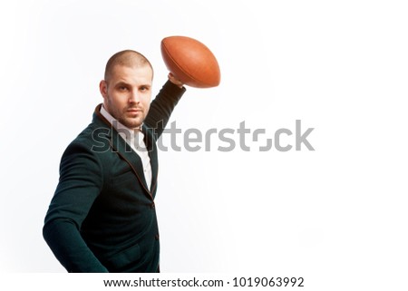 Young bald man, confident business man in white shirt, green suit and rugby ball looking at camera on white isolated background
