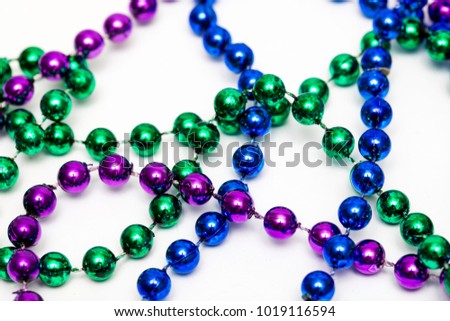 Mardi gras beads necklace against a white background