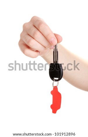 Car key with charm in hand isolated on white