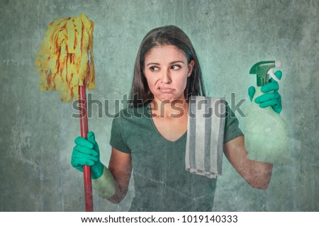 grunge edit portrait of sad and depressed lazy cleaning woman , housewife or house maid service cleaner girl looking tired and frustrated holding mop and detergent spray in domestic work concept