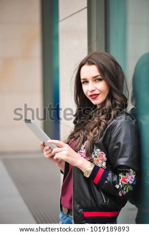 young girl using tablet in the street, hipster style, outdoor portrait, happy face