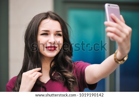 Young hipster woman, making selfie, funny face, posing at countryside at summer day.