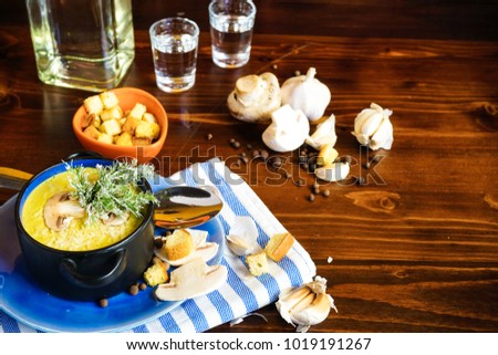 Rustic dinner set with healthy   mushroom cream soup with spices on dark wooden table