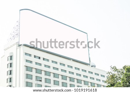 Blank billboard on white building.