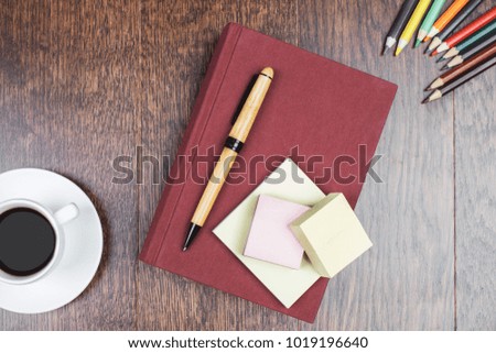 Top view of wooden office desk with book, coffee cup and supplies. Workplace concept 