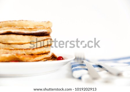 Stack of pancakes with berries and sugar