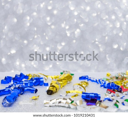Carnaval festive curling paper and confetti decorations on silver background with copy space