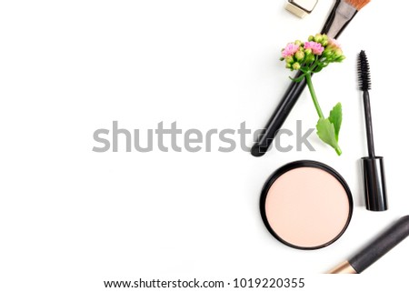 Makeup brushes, powder, and a mascara applicator, shot from above on a white background with copy space. A template for a makeup artist's business card or flyer design