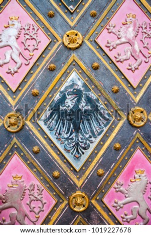 Element of doors of St. Peter and St. Paul Basilica in Vysehrad, Prague. Coat of arms of Bohemia - silver double-tailed lion on a red background.  Bohemian Lion. Coat of arms of Silesia - eagle.