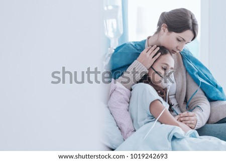Older sister and girl in the hospital breathing using an oxygen mask Royalty-Free Stock Photo #1019242693