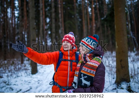 Image of woman and man showing hand forward in winter forest