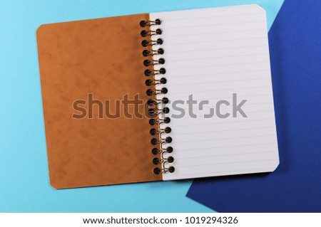 Empty open striped notebook close up on blue background