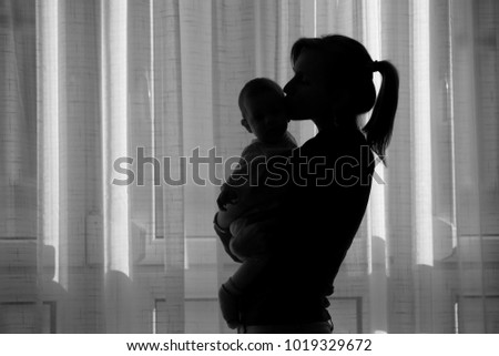 Silhouette of a young mother with her baby.