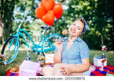 Group of friends at park having fun party. Beautiful girl with a lollipop in hands