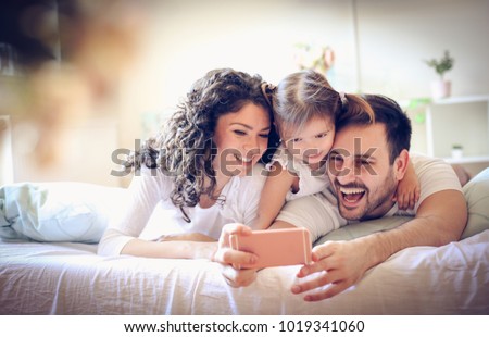 Happy young family take a self portrait with smart phone. 