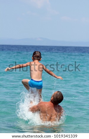 Father and son play in water