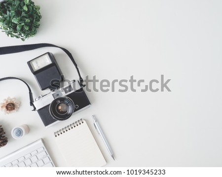 top view office table concept with retro camera, notebook and keyboard on white Color table background with copy space