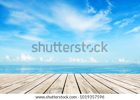 Wooden floor with blue sea and sky background  Royalty-Free Stock Photo #1019357596