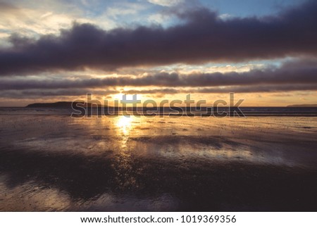 Yellow sunrise with a few clouds on beach in Rush Ireland