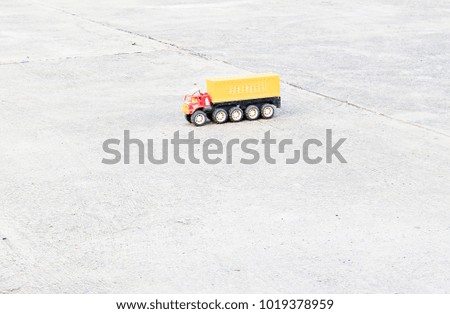 Plastic toy truck with bright colors on the empty concrete floor.