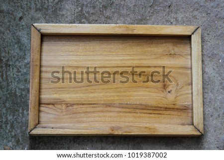 An empty wooden sign on concrete background.