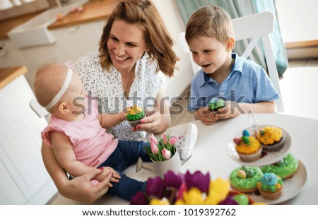 Mother and children painting colorful eggs