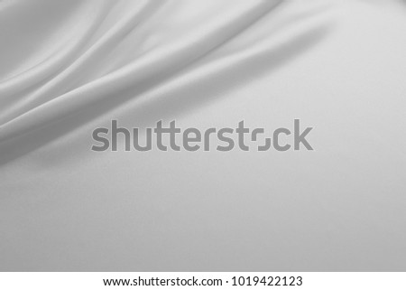 Smooth elegant white silk or satin luxury cloth fabric texture, abstract background design.