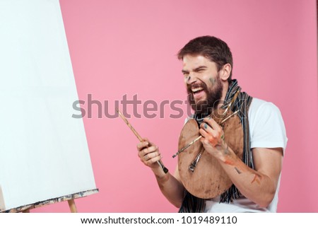  painter with a brush, a palette on a pink background                              