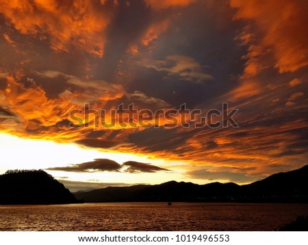 Orange sky landscape after sunset over the lake