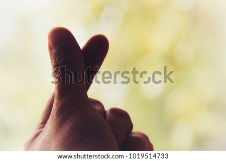Hand-shaped heart symbol, i love you hand sign on nature light bokeh background 