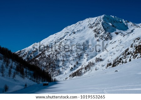 Beautiful mountain valley during winter whit snow covered mountains under blue sky