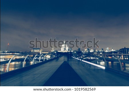 Long exposure on Millennium Bridge at dark night on London skyline