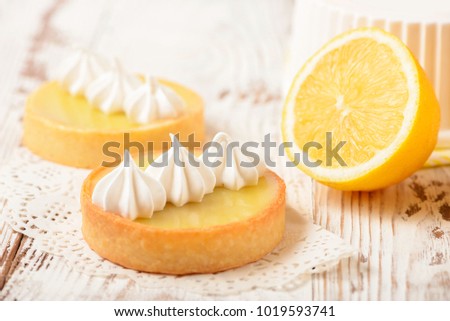 Lemon pie on the table with citrus fruits. Traditional french sweet pastry tart. Delicious, appetizing, homemade dessert with lemon curd cream. Copy space