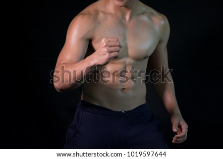 Bodybuilder posing muscular body on black background