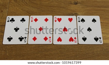 poker cards on a wooden backround, set of ten of clubs, diamonds, spades, and hearts