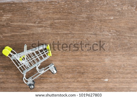 Shopping cart on wood background, space for text. Online shopping concept. 