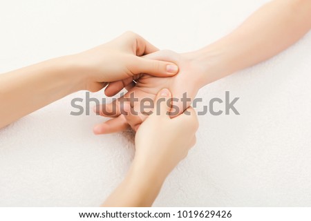 Hand massage. Physiotherapist pressing specific spots on female palm. Professional health and wellness acupressure manipulations, copy space, closeup Royalty-Free Stock Photo #1019629426