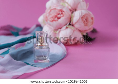 Bouquet of peonies and perfume on pink background. Bride's morning concept