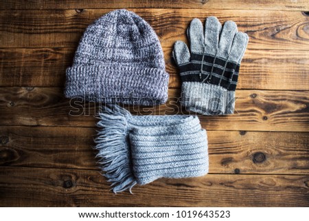 a grey winter hat gloves scarf on a wooden bacground Royalty-Free Stock Photo #1019643523