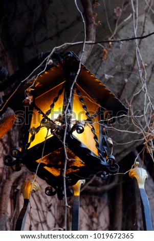 Close up picture of a retro metal street lantern in Vienna. Fairy tale, medieval or halloween vibes provided by soft evening lightening.
