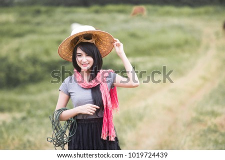 Beautiful cowgirl on the field grass